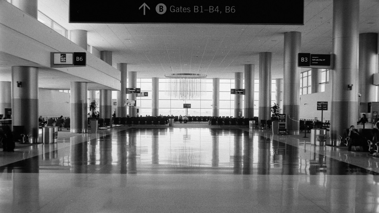 A wide airport concourse with gate signs pointing the way to the departure gates